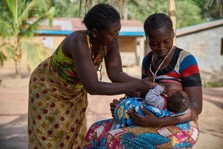 A mother is breastfeeding a baby